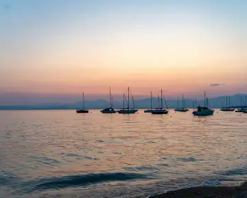 Segelboote auf dem Gardasee in der Abenddämmerung