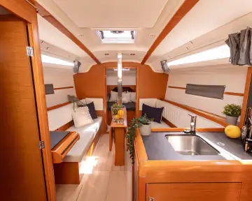 Heller Salon mit Sitzbereich und Bordküche im Segelboot