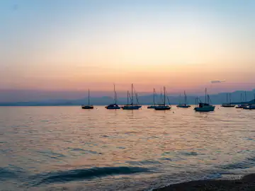 Segelboote auf dem Gardasee in der Abenddämmerung