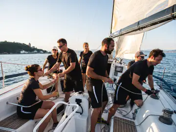 Team beim gemeinsamen Segelmanöver auf dem Gardasee