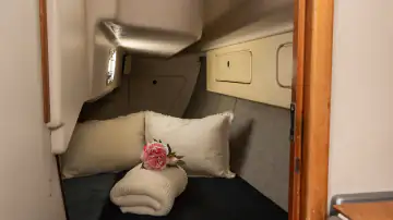 Gemütliche Doppelkabine mit Kissen und Decke unter Deck