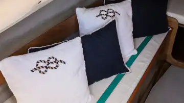 Sitzbereich im Innenraum eines Segelboots mit Kissen und Holzelementen