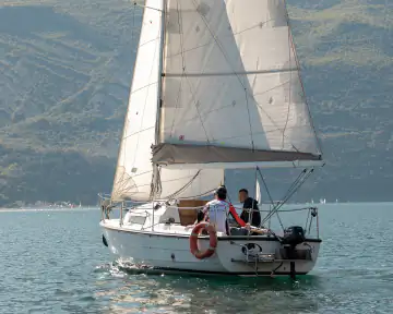 Segelboot mit Crew bei einer sportlichen Ausfahrt auf dem Gardasee