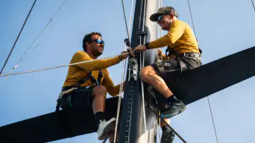 Zwei Segler bei Arbeiten am Mast eines Segelboots